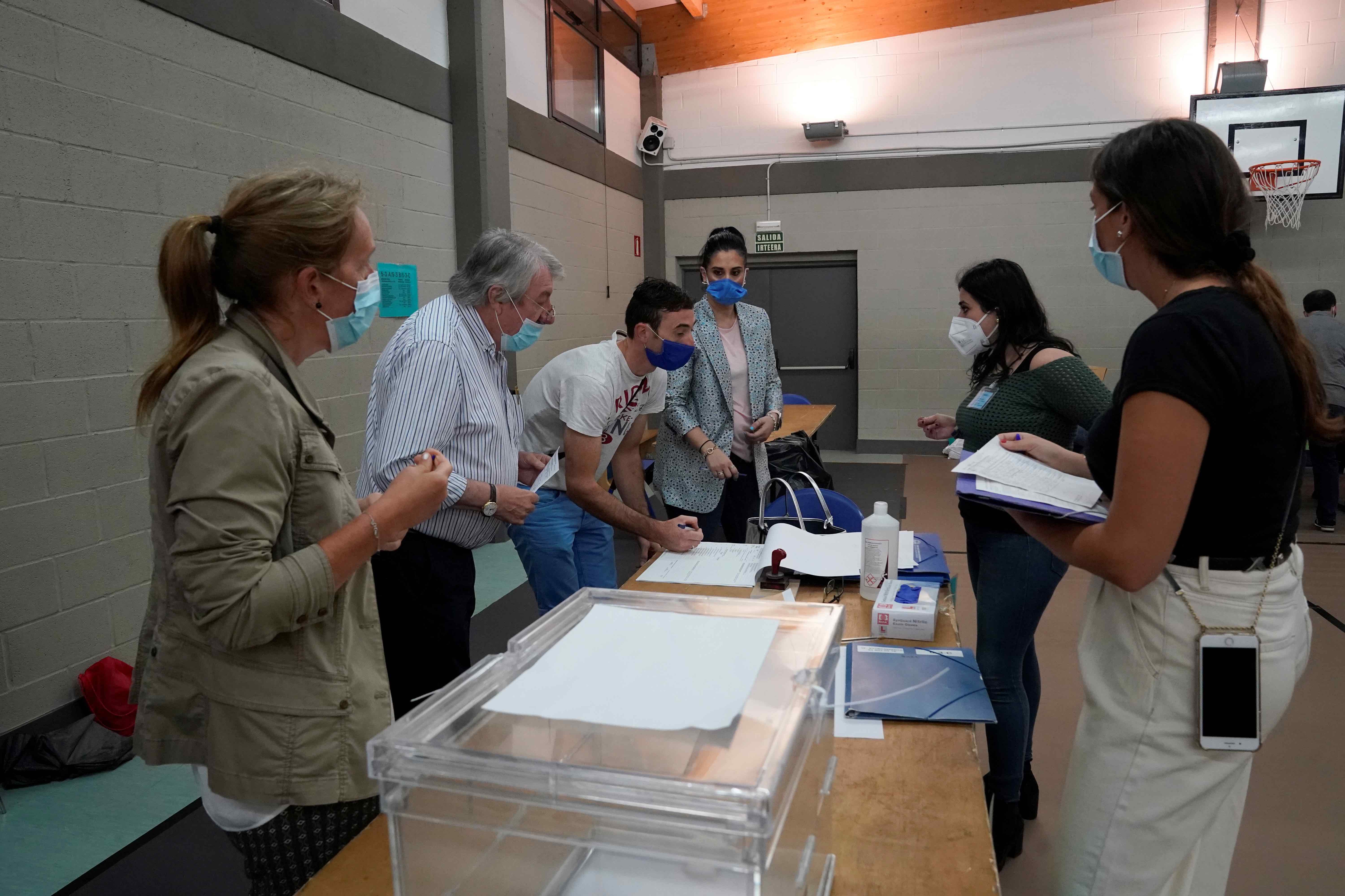 Workers organize papers at a polling station before the start of the voting during the Basque regional elections, amid the coronavirus disease (COVID-19) outbreak, in Durango, July 12, 2020 (by REUTERS/Vincent West)